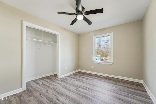 unfurnished bedroom with ceiling fan, light hardwood / wood-style floors, and a closet