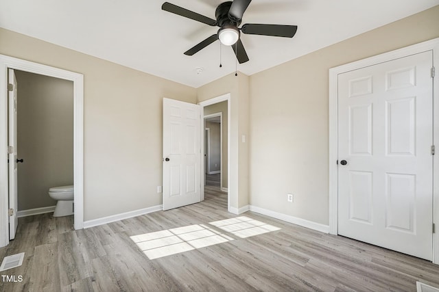 unfurnished bedroom with ceiling fan, connected bathroom, and light hardwood / wood-style flooring