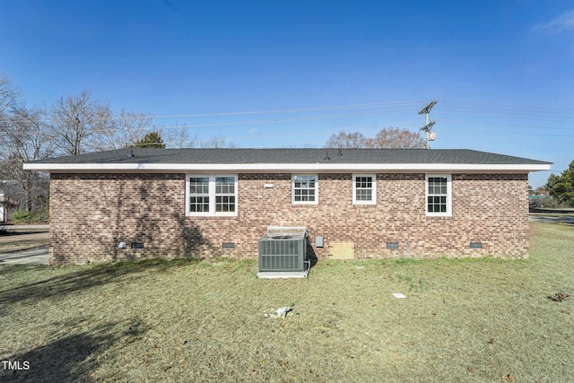 back of property featuring cooling unit and a lawn