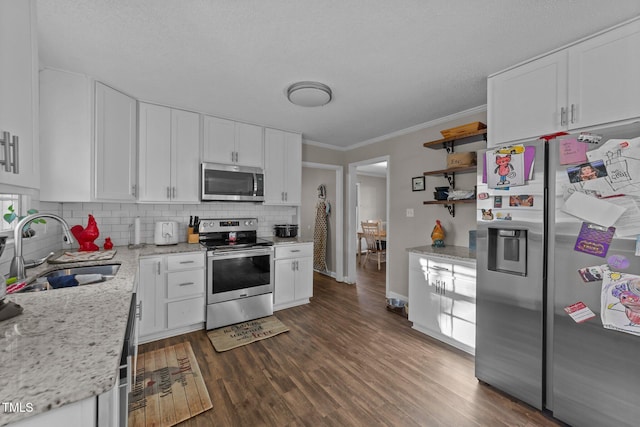 kitchen featuring white cabinetry, sink, backsplash, stainless steel appliances, and light stone countertops