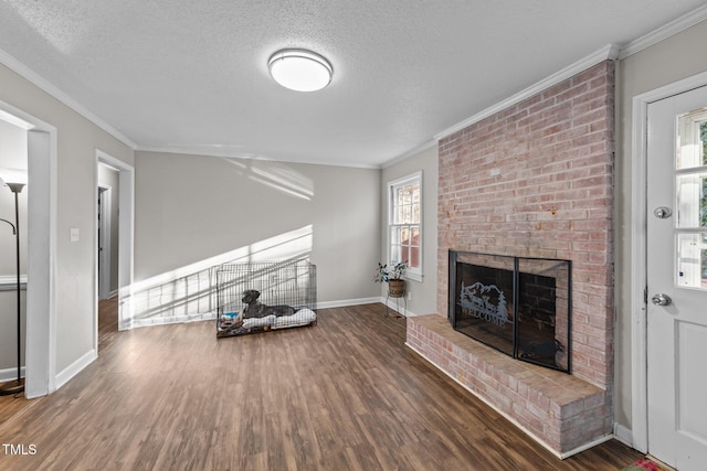 unfurnished living room with crown molding, dark hardwood / wood-style floors, a textured ceiling, and a fireplace