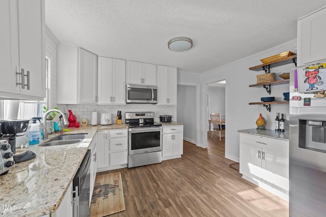 kitchen with sink, light stone counters, appliances with stainless steel finishes, dark hardwood / wood-style floors, and white cabinets