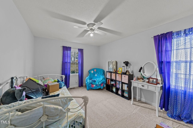 bedroom with ceiling fan, light colored carpet, and a textured ceiling