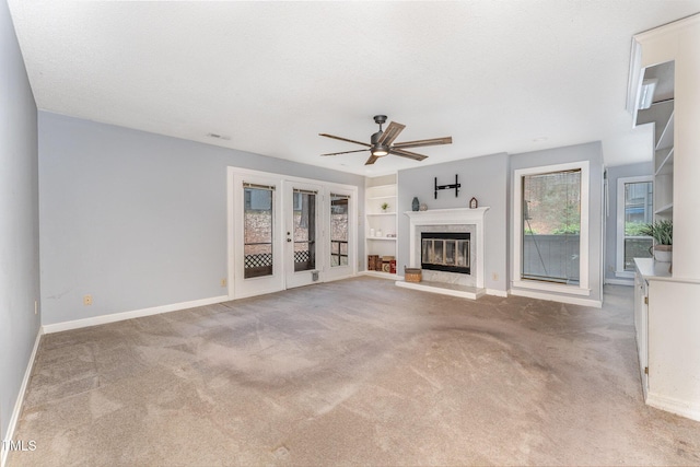 unfurnished living room with french doors, ceiling fan, carpet floors, and a textured ceiling