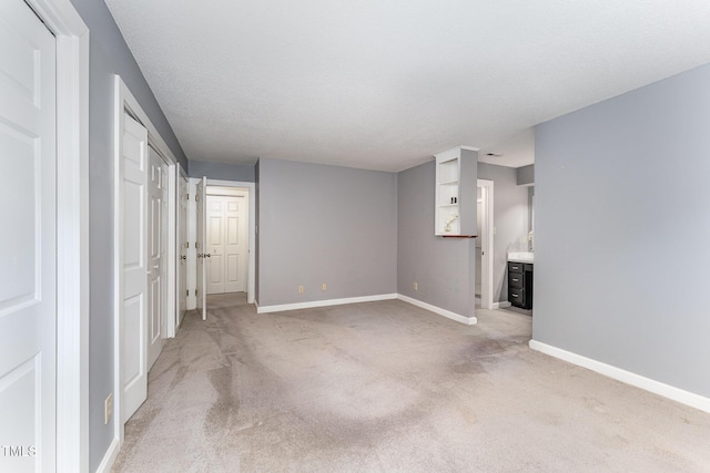 unfurnished living room featuring light colored carpet and a textured ceiling