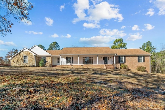 ranch-style home featuring a porch and a front lawn