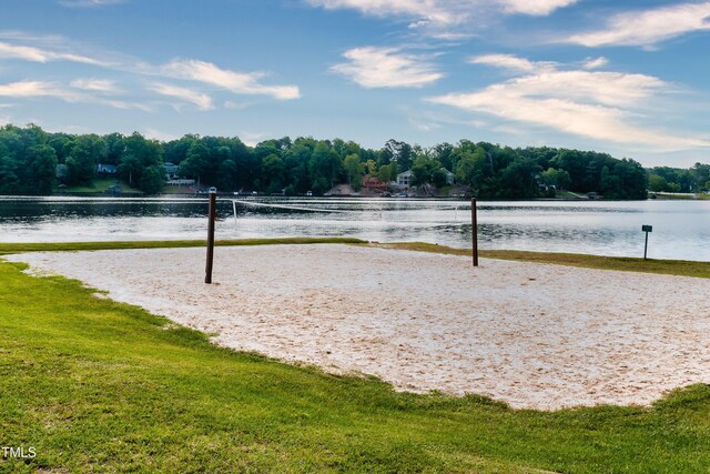 view of community with a water view, a lawn, and volleyball court