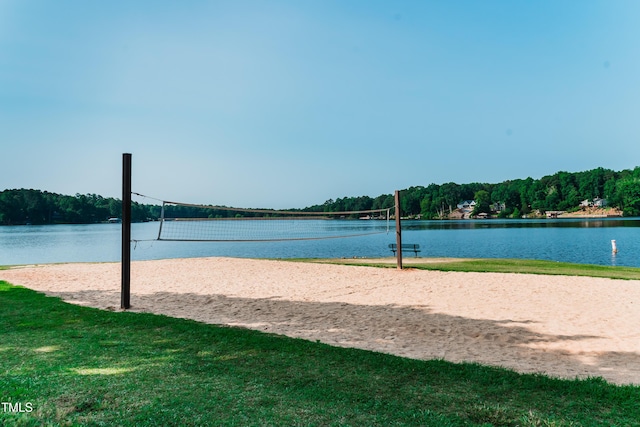 view of property's community featuring a yard, a water view, and volleyball court