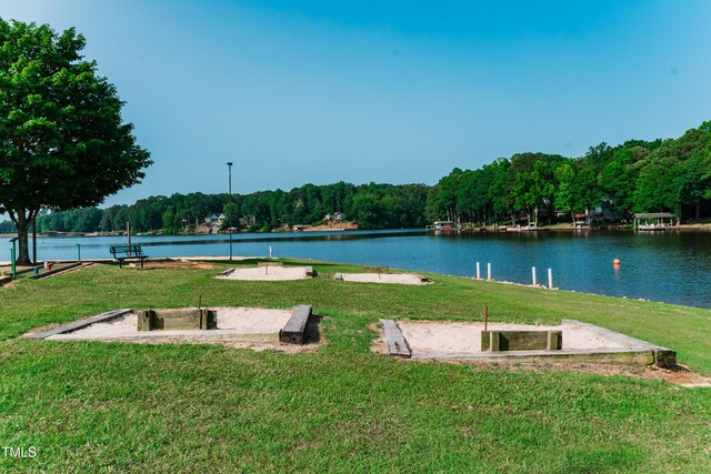 surrounding community with a yard and a water view