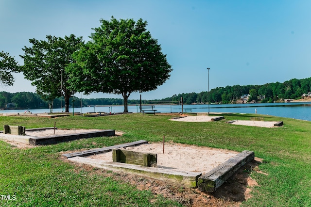 view of property's community with a yard, a water view, and volleyball court