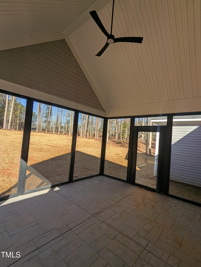 unfurnished sunroom with ceiling fan, vaulted ceiling, and a healthy amount of sunlight