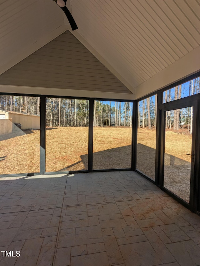 unfurnished sunroom featuring vaulted ceiling