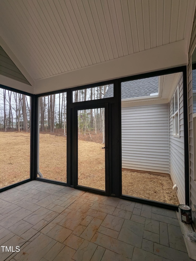 unfurnished sunroom featuring vaulted ceiling