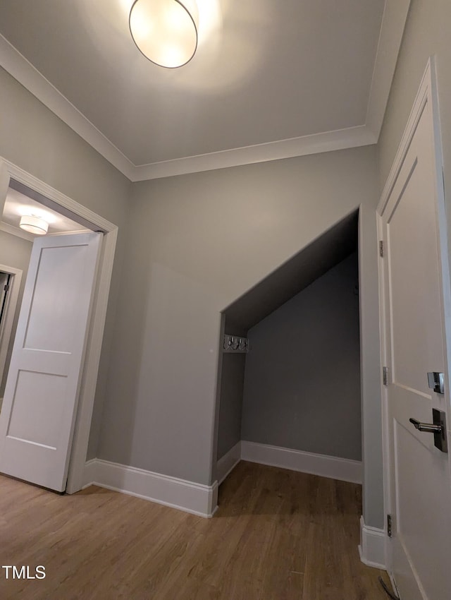 corridor with hardwood / wood-style flooring and ornamental molding