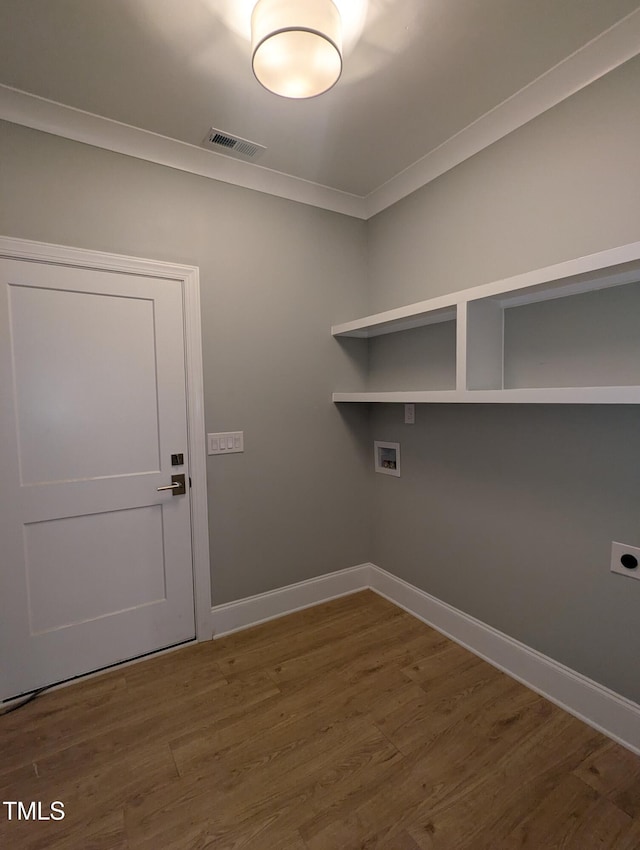 laundry area featuring hookup for a washing machine, dark wood-type flooring, crown molding, and hookup for an electric dryer