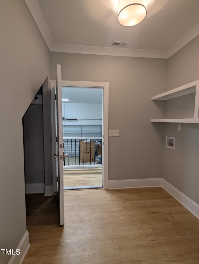 washroom with washer hookup, crown molding, and hardwood / wood-style floors