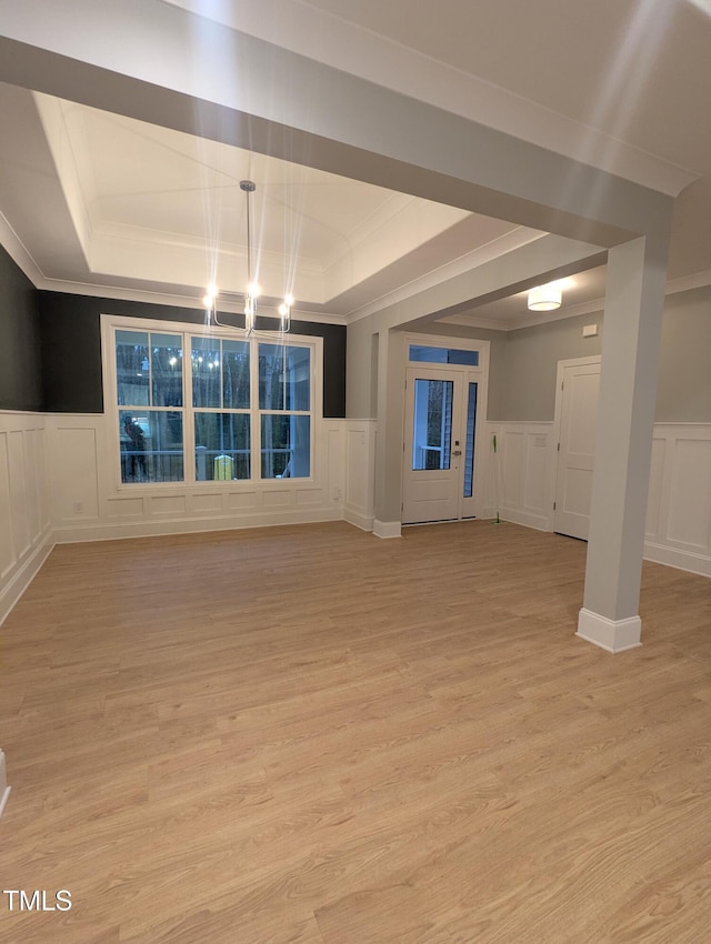 interior space with a notable chandelier, ornamental molding, and light hardwood / wood-style floors