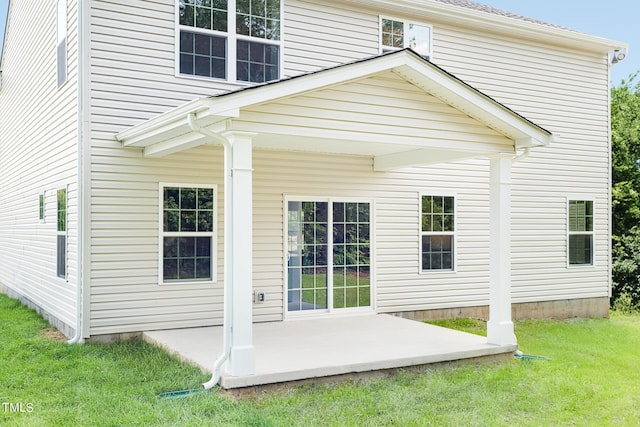 back of house with a lawn and a patio