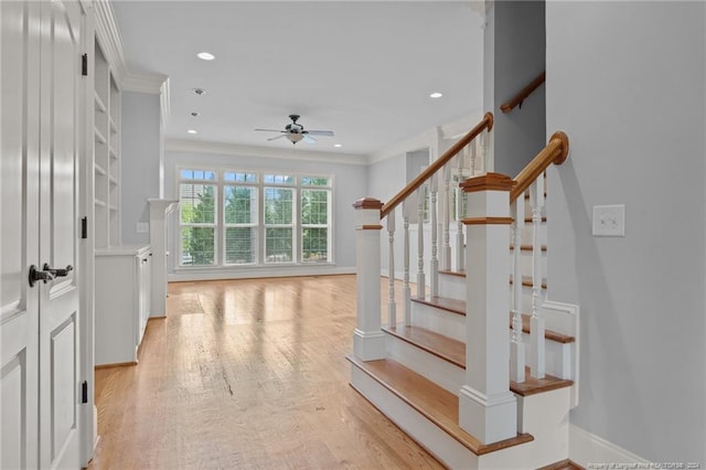 stairway featuring ceiling fan, hardwood / wood-style floors, and ornamental molding