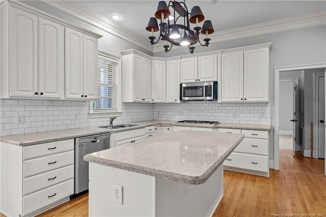 kitchen with light wood-type flooring, a center island, stainless steel appliances, and white cabinetry