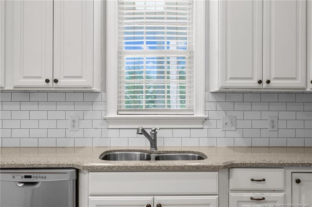 kitchen with dishwasher, white cabinets, tasteful backsplash, and sink