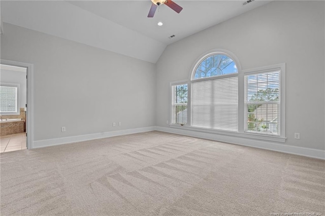 unfurnished room with a wealth of natural light, light colored carpet, and lofted ceiling