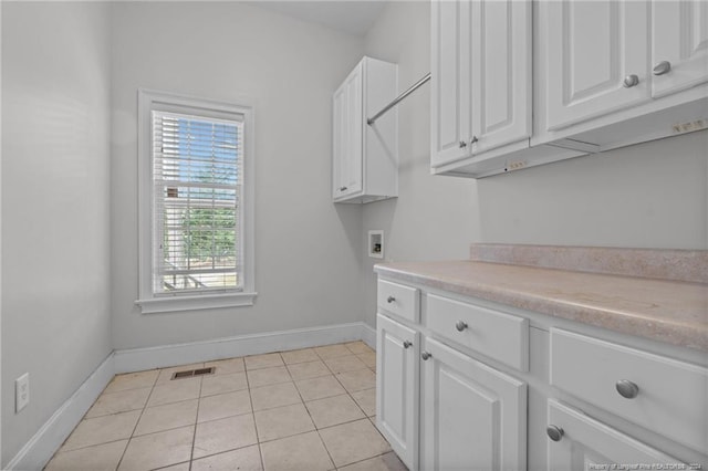 laundry area featuring cabinets, light tile patterned floors, and hookup for a washing machine