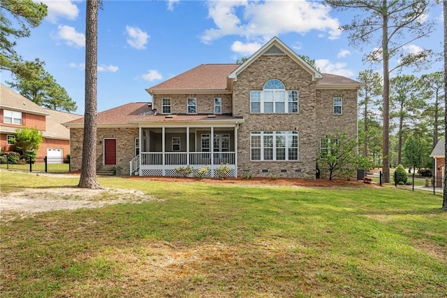 rear view of house featuring a sunroom and a yard