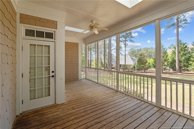 unfurnished sunroom featuring a skylight and ceiling fan