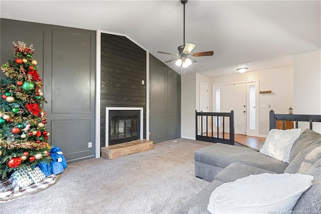 carpeted living room featuring ceiling fan, a fireplace, and lofted ceiling