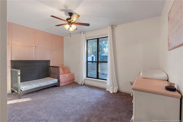 living area featuring dark carpet and ceiling fan