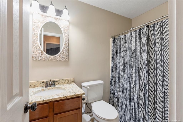 bathroom with vanity, a textured ceiling, and toilet