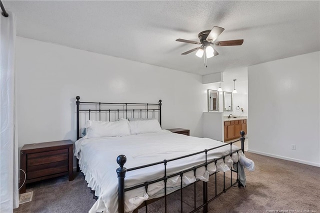 bedroom featuring ceiling fan, dark carpet, a textured ceiling, and ensuite bath