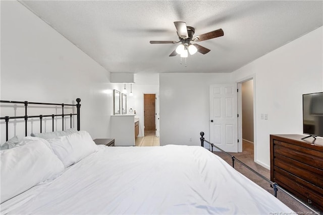 bedroom featuring a textured ceiling, ensuite bath, and ceiling fan