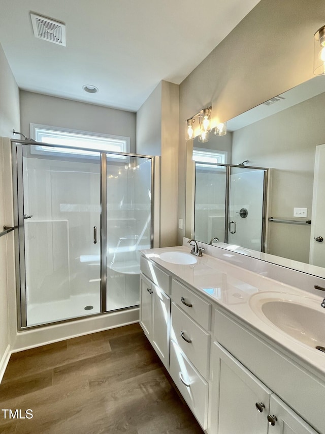 bathroom with hardwood / wood-style flooring, vanity, and walk in shower