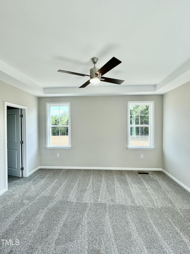 carpeted empty room featuring plenty of natural light and ceiling fan