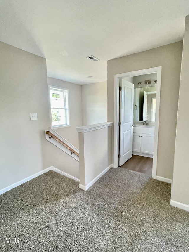 hallway featuring carpet floors and sink