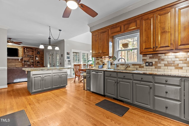 kitchen with light stone counters, stainless steel dishwasher, pendant lighting, gray cabinetry, and sink