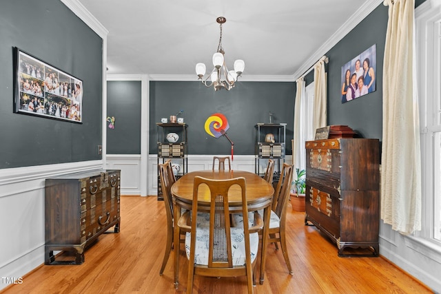 dining space with ornamental molding, light hardwood / wood-style flooring, and a notable chandelier