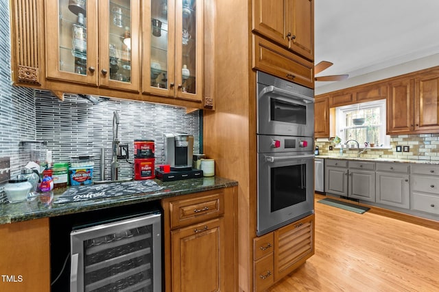 kitchen with dark stone counters, backsplash, wine cooler, and light hardwood / wood-style flooring