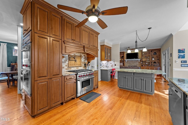 kitchen featuring stainless steel appliances, a center island, decorative backsplash, light stone countertops, and pendant lighting