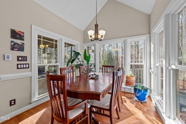 dining space featuring lofted ceiling, light hardwood / wood-style floors, and a chandelier