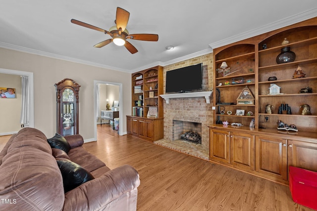 living room featuring light hardwood / wood-style flooring, built in shelves, crown molding, a fireplace, and ceiling fan