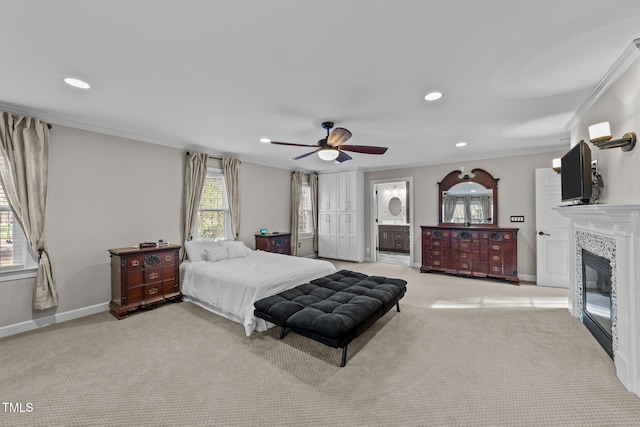 bedroom with ceiling fan, light colored carpet, ornamental molding, and ensuite bath