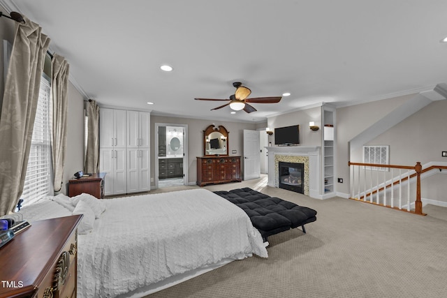 carpeted bedroom with ceiling fan, ensuite bathroom, and crown molding