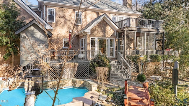 back of house featuring a balcony and a sunroom