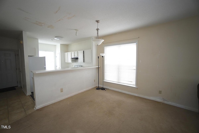 kitchen with pendant lighting, white cabinetry, plenty of natural light, and light colored carpet