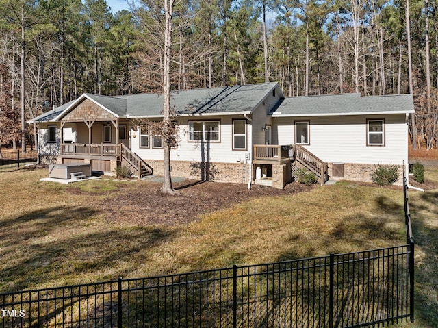 ranch-style home featuring a wooden deck and a front yard