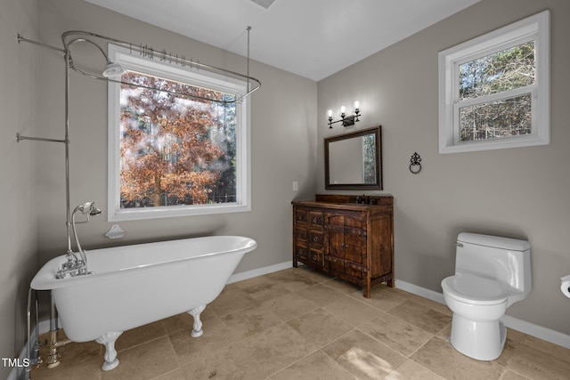 bathroom featuring vanity, toilet, and a tub