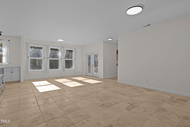 unfurnished living room featuring french doors